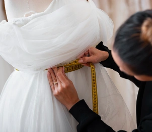 Het opmeten van een jurk op een model met een meetlint, nauwkeurige pasvorm en het proces van kleding op maat.
