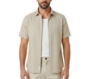 Man in een minimalistische beige outfit met een shirt met korte mouwen en een broek, strakke moderne herenmode op een witte achtergrond.