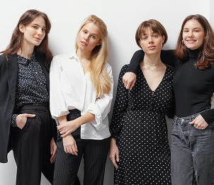 Een groep stijlvolle vrouwen poseert samen in moderne, casual outfits en laat daarmee hedendaagse mode en zelfvertrouwen zien.